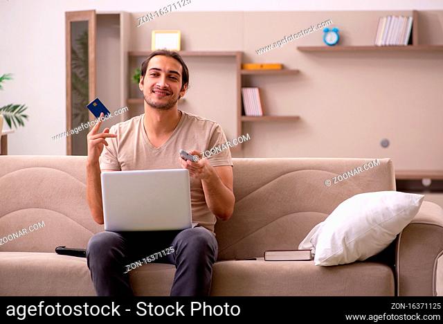 Young man ordering by credit card at home