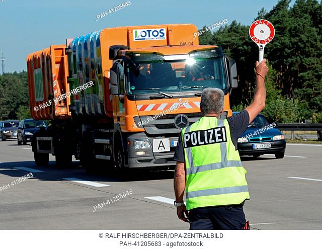 A police officer stops a truck at the A2 motorway near Brandenburg, Germany, 22 July 2013. The police headquarters West has ordered several traffic controls as...