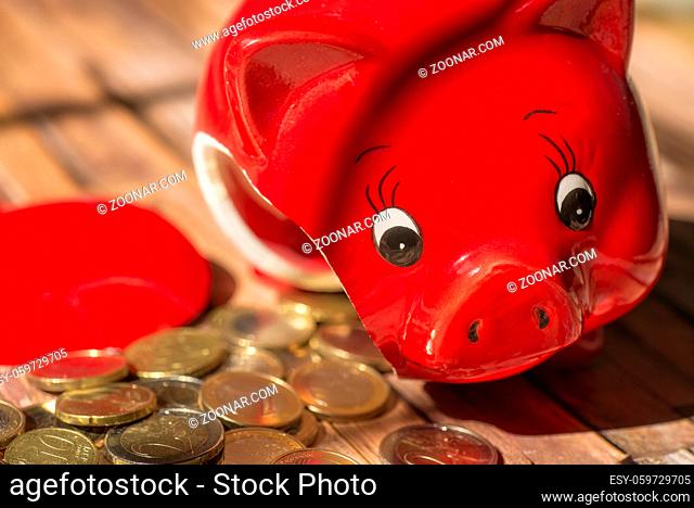Zerbrochenes Sparschwein mit vielen Münzen