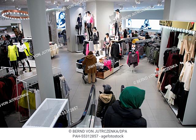 Pedestrians walk through a clothing shop by H&M in Berlin, Germany, 23 January 2015. The Swedish fashion label Hennes & Mauritz provides its annual figures on...