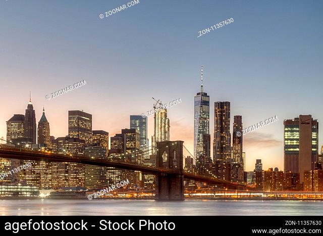 Skyline of Lower Manhattan and Brooklyn Bridge during sunset time