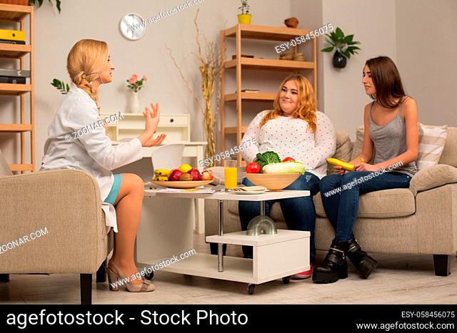 Two girls and dietitian having discussion. Healthy lifestyle concept
