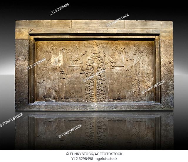 Assyrian relief sculpture panel of King Ashurnasirpal II dressed in Ritual robes, he is depicted twice on either side of the central sacred tree of life