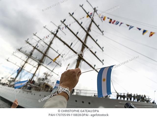 Visitors of the 'Ueberseebruecke' (lit. oversears bridge) wave with small Argentinian flags while the Argentinian training sailing ship 'Libertad' enters the...