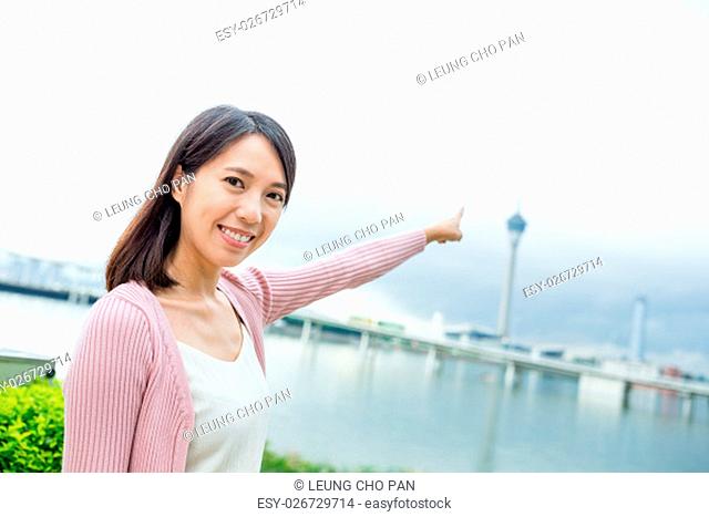 Woman finger pointing to the Macau tower