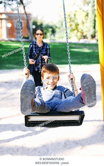 Happy boy on a swing at the playground