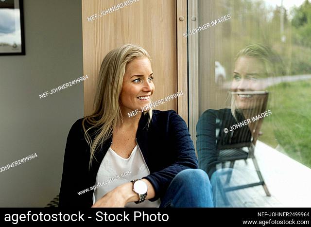 Blond woman looking through window