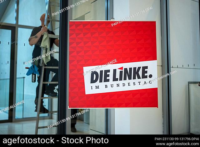 30 November 2023, Berlin: A window cleaner climbs down the ladder next to the rooms of the Left Party parliamentary group in the Bundestag