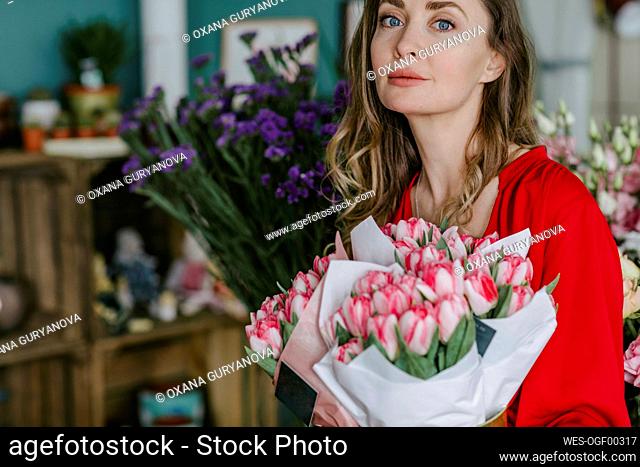 Portrait of a woman with a bouquet of flowers in a flower shop