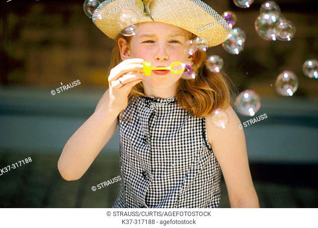 8 years old girl blowing bubbles