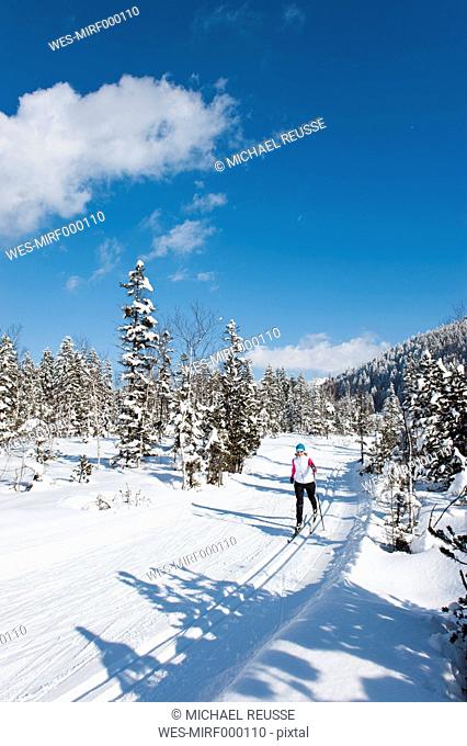 Germany, Bavaria, Aschermoos, Senior woman doing cross-country skiing