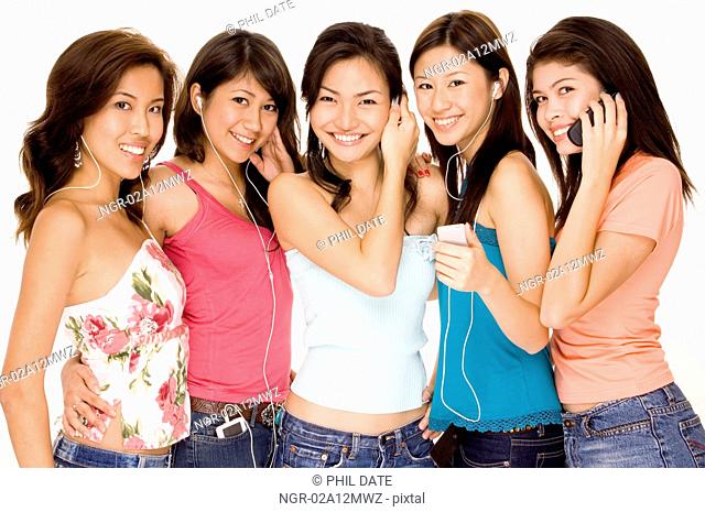 Four young women and a teenage girl using MP3 players and mobile phones