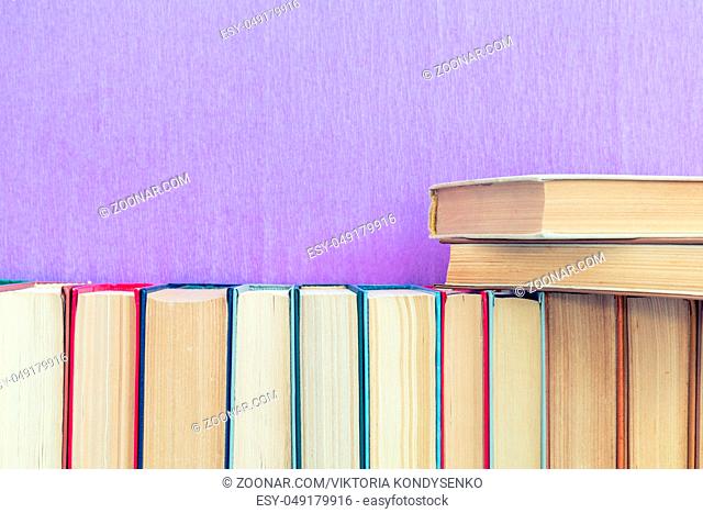 Books background. Many different books on violet wall
