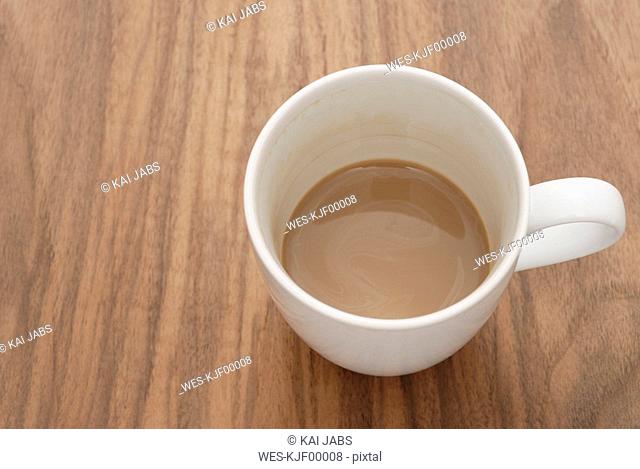 Cup of coffee on wooden table, elevated view