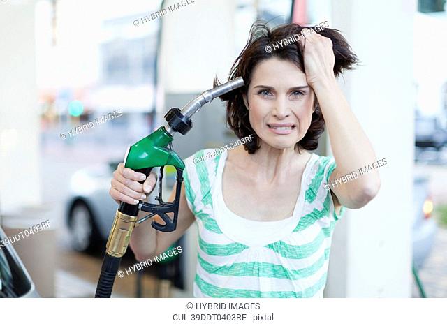 Frustrated woman pumping gas into hair