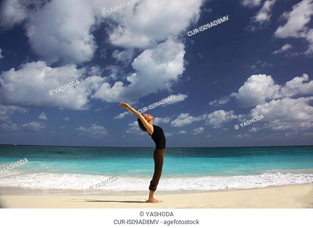 Mature woman doing yoga on beach, Paradise Island, Nassau, Bahamas
