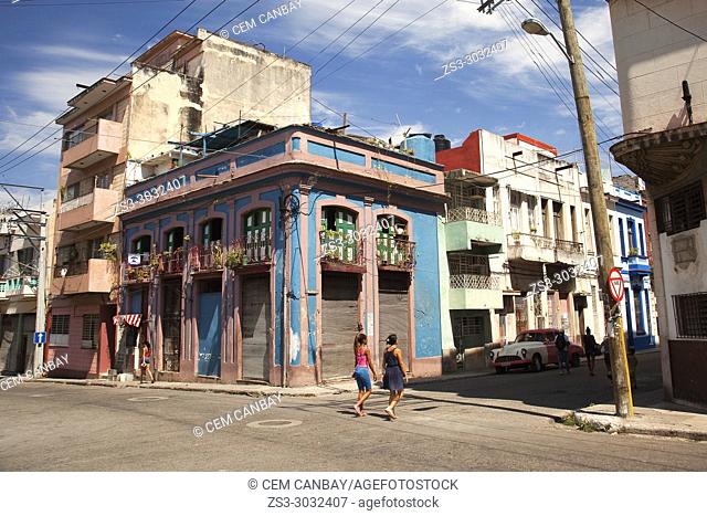 Women walking in the street in front of the colonial buildings at Vedado district, Havana, La Habana, Cuba, Central America