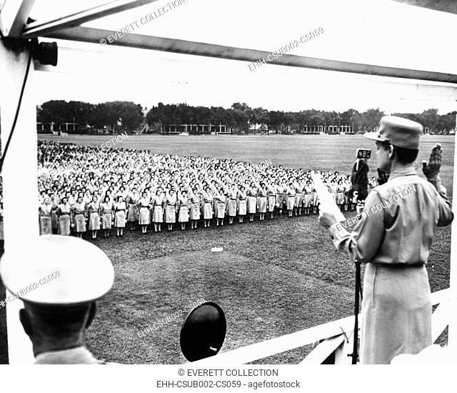 Col. Oveta Culp Hobby administering the Army oath to several thousand women. Aug. 5, 1943. They were in newly named, 'Women's Army Corps