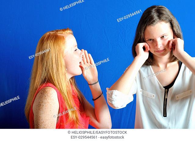 Two teen, one shouting the other plug her ears