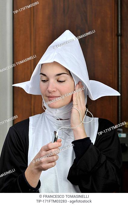 Young nun listening to music with mp3 player