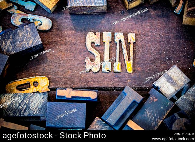 The word SIN written in rusted metal letters surrounded by vintage wooden and metal letterpress type