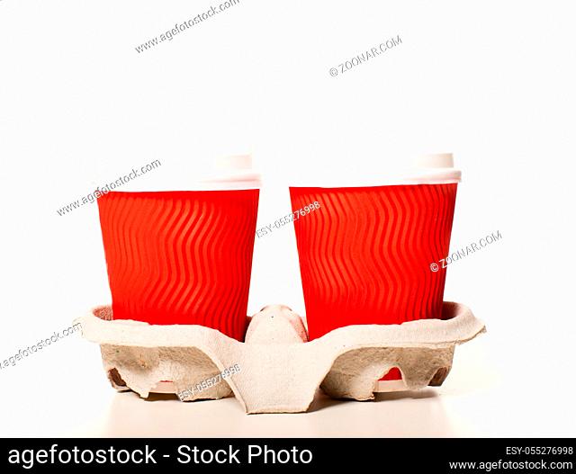Disposable red paper coffee cups of different sizes standing in a row on a white background, mockup for design for espresso, cappuccino, latte