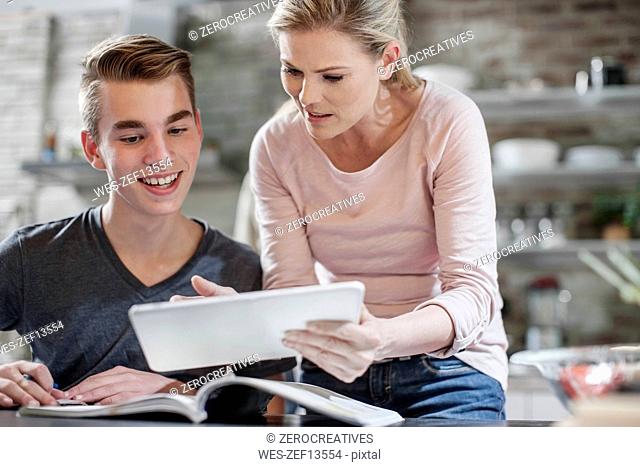 Mother and son with tablet and book