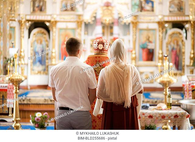 Couple and priest standing in church