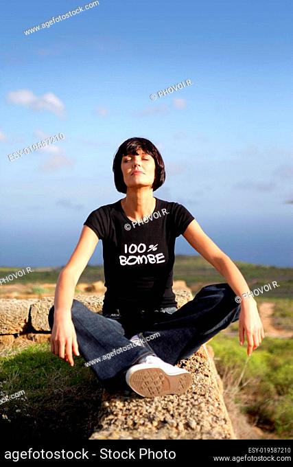 woman sitting cross-legged on the walls made of black t-shirt
