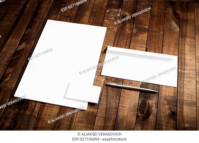 Photo of blank stationery set on wooden table background. Blank letterhead, business cards, envelope and pen. Mock up for branding identity