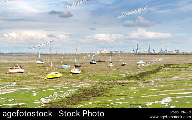 Boats at low tide at the shore of the River Medway in Lower Halstow, Kent, England, UK