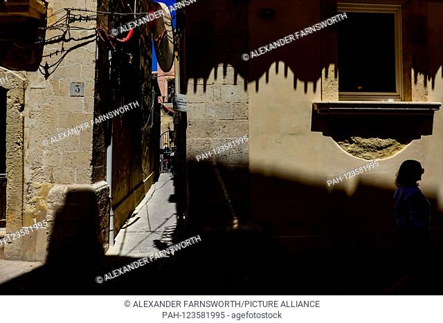 Syracuse, Sicily, Italy People walking through strong shadows on a back street on Ortygia island. | usage worldwide. - Syracuse/Sicily/Italy