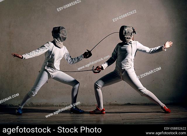 Fencer woman with fencing sword. Fencers duel concept