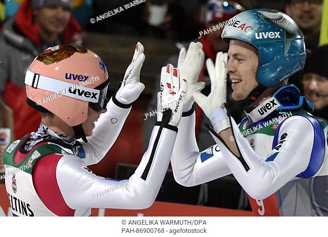 Austrian ski jumpers Stefan Kraft (l) and Michael Hayboeck celebrates after their jumps in the second round at the 65th Four Hills Tournament on the...