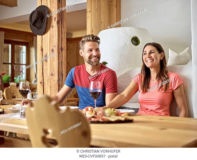 Happy couple having a snack in an alpine cabin