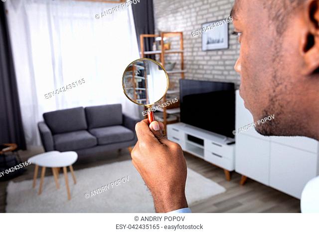 Man Searching In The House With Magnifying Glass