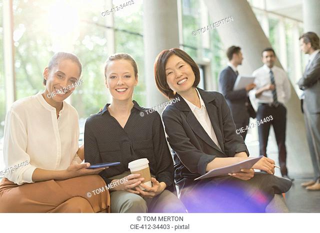 Portrait smiling businesswomen meeting in office lobby