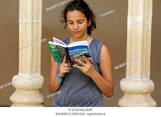 Teenager reading a guidebook