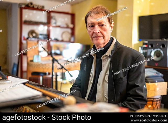 19 December 2023, Bavaria, Geiselhöring: Hans-Jürgen Buchner from the music group Haindling sits at a grand piano in his home in Haindling