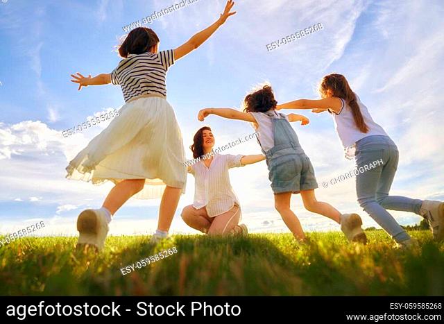 Happy family on summer walk! Mother and daughters walking in the Park and enjoying the beautiful nature
