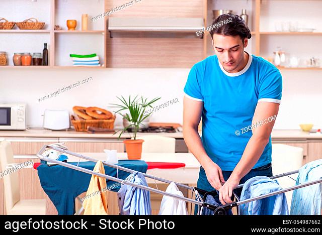 Young man husband doing clothing ironing at home