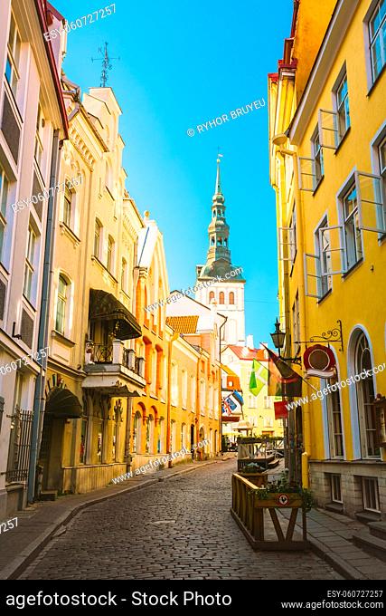 Tallinn, Estonia. View Of Narrow Street In Sunny Summer Day Under Blue Sky. Old Architecture And Different Cafes And Restaurants In Popular Touristic Route
