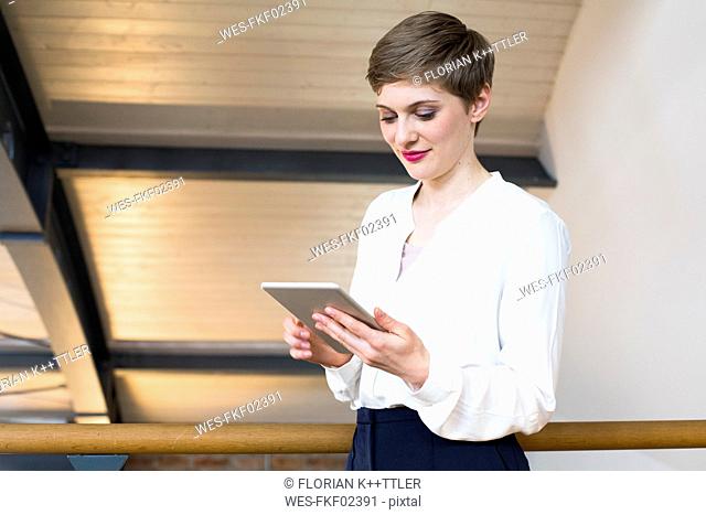 Smiling businesswoman looking at tablet