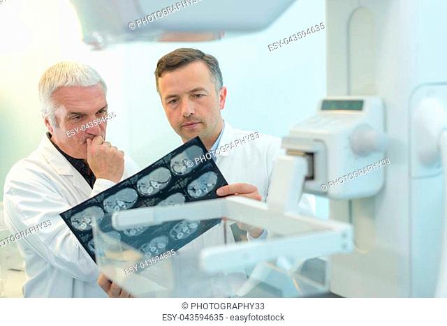 two yound doctors examining a x-ray film at the diaphanoscope