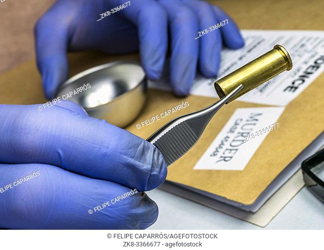 Scientific police examining a bullet cap in ballistic Laboratory, conceptual image