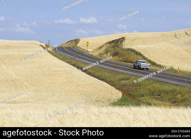 One vehicle driving on a rural highway in the Palouse farming area of eastern Washington State, USA