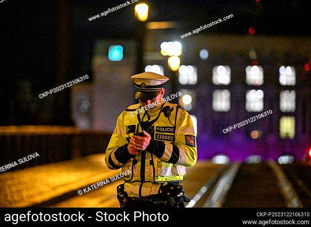 A police officer patrols the closed Manes Bridge heading towards Jan Palach Square, where shots were fired in the Faculty of Arts building, in Prague