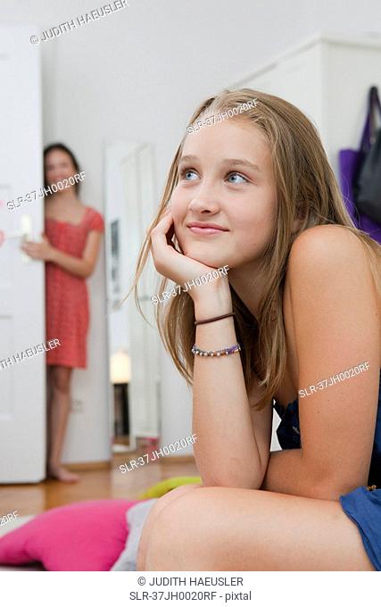 Smiling girl sitting with chin in hand
