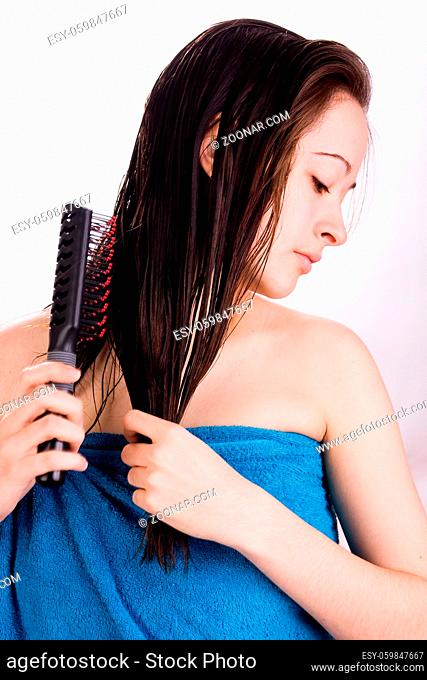 Woman is brushing her hair in the studio
