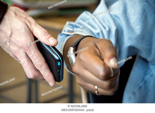 Woman paying with smartwatch and NFC reader